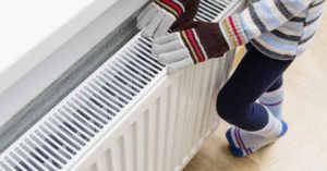 woman with gloves on because of heating problem