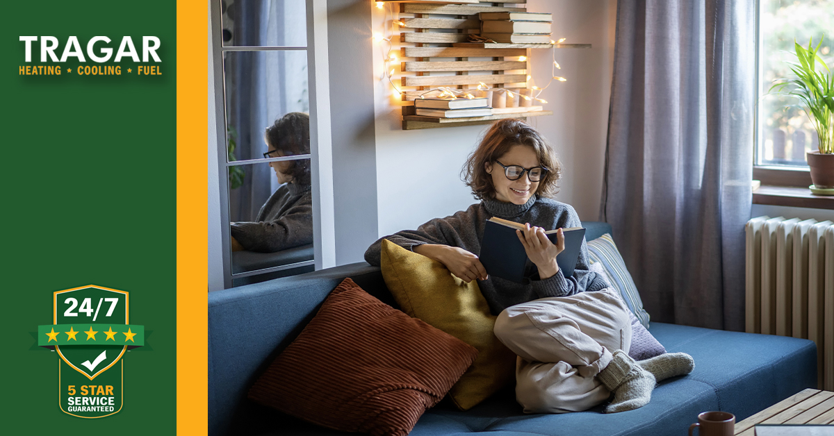 Woman comfortable reading on her couch.